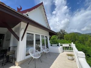 a patio with two chairs and a table on a balcony at Villa H in Surin Beach +10 photos