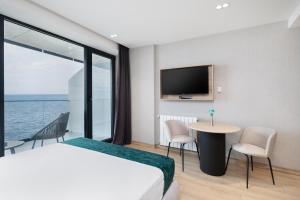 a bedroom with a bed and a table and a tv at Marina Club in Batumi