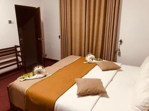 two beds in a hotel room with stuffed animals on them at Marigoldhome hotel and restaurant in Nuwara Eliya