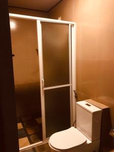 a bathroom with a toilet and a glass shower stall at Marigoldhome hotel and restaurant in Nuwara Eliya