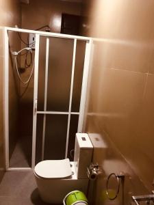 a small bathroom with a toilet and a shower at Marigoldhome hotel and restaurant in Nuwara Eliya