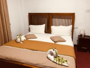 a bedroom with a large bed with decorations on it at Marigoldhome hotel and restaurant in Nuwara Eliya