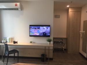 a room with a desk with a tv on the wall at Fuller Hotel Kulim in Kulim