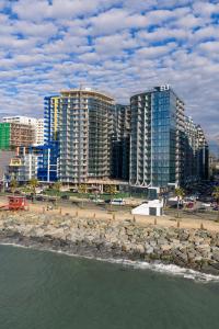 a group of tall buildings on a beach with the water at Marina Club in Batumi