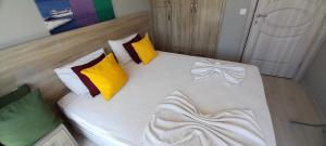 a bed with yellow and white pillows in a room at Ölüdeniz Günlük Kiralık Daire & Apart havuzlu in Oludeniz