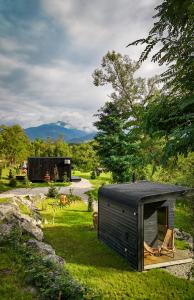a small black tiny house in the grass at Forest Chalet in Porumbacu de Sus