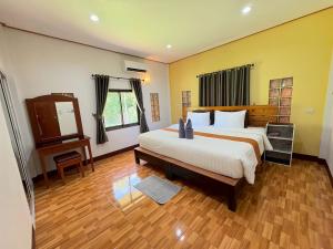 a bedroom with a large bed and a wooden floor at Rimlay Bay View 2 in Ko Yao Noi