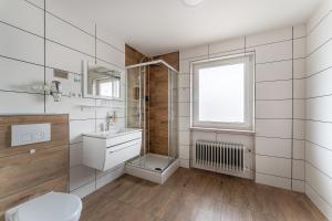a bathroom with a sink and a toilet and a window at Hotel Glas Schwarzwald in Fluorn