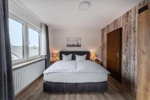 a bedroom with a large bed and two windows at Hotel Glas Schwarzwald in Fluorn
