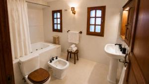 a bathroom with a toilet and a tub and a sink at Centrally located lakefront house in San Carlos de Bariloche +17 photos