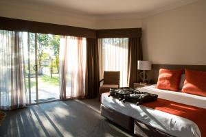 a hotel room with a bed and a large window at Hunter Gateway Motel in Maitland