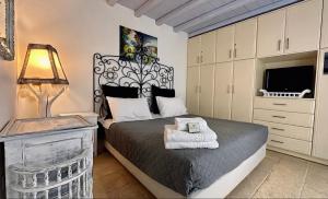 a bedroom with a bed and a lamp and a dresser at Mimoza Collection suites in Ornos +45 photos