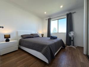 a bedroom with a bed and a large window at Sound Views Apartment in Safety Bay +2 photos