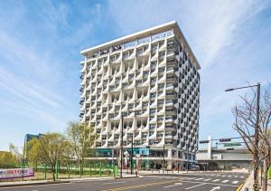 a tall white building on a city street at Kinstay Hotel in Goyang