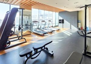 a gym with a row of treadmills and machines at Kinstay Hotel in Goyang