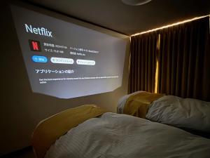 a projection screen in a room with a bed at 凪 nagi Awaji in Awaji