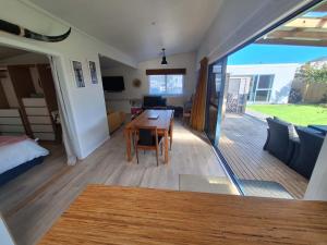 a room with a dining table and a living room at Beach Pad in Whangamata