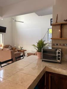 a kitchen with a counter top with a microwave on it at Cocos House Zicatela in Puerto Escondido
