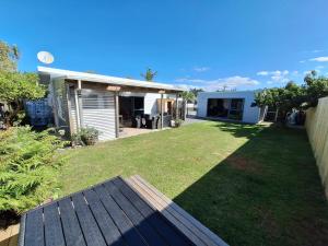 a backyard of a house with a grass yard at Beach Pad in Whangamata