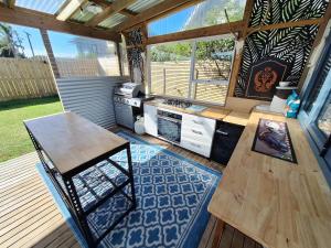 an outdoor kitchen with a table and a stove at Beach Pad in Whangamata