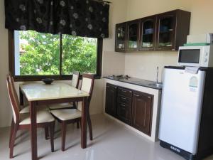 a small kitchen with a table and a refrigerator at Viking House Apartment in Ko Tao