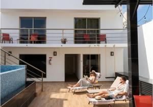 a group of people sitting in chairs on a building at Casa Balam Gladiolas in Cancún