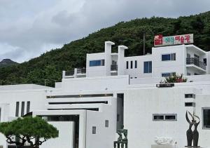a white building with two statues in front of it at HwiMokArt Resort in Buan
