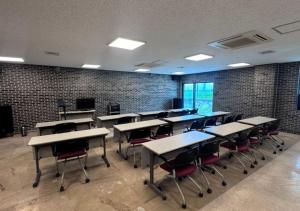 a classroom with tables and chairs in a brick wall at HwiMokArt Resort in Buan