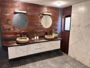 a bathroom with two sinks and a wooden wall at Cabañas M&S By GEstores in Huasca de Ocampo +41 photos