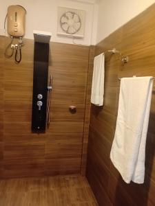 a bathroom with a shower with two towels and a clock at River View Inn in Maskeliya