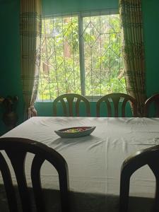a table with a bowl of food on it in front of a window at River View Inn in Maskeliya