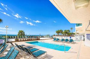 a swimming pool with chairs and the ocean in the background at Ashworth 303 in North Myrtle Beach