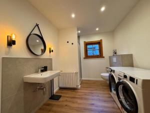 a bathroom with a sink and a washing machine at Einzigartiges Alpenstil Chalet mit Panoramablick in Hausen-Wied +42 photos