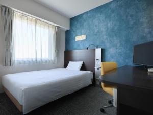 a bedroom with a bed and a desk with a computer at Comfort Hotel Koriyama in Koriyama