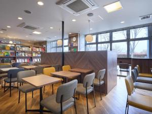 a restaurant with tables and chairs and books at Comfort Hotel Koriyama in Koriyama