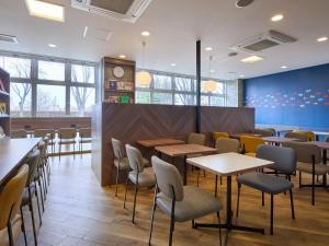 a restaurant with tables and chairs in a cafeteria at Comfort Hotel Koriyama in Koriyama