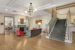 a living room with a staircase and red chairs at Comfort Inn & Suites Dover in Dover