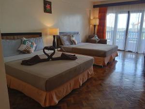 a hotel room with two beds and a couch at Alta Vista Residences H102 in Boracay