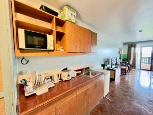 a kitchen with a counter with a sink and a microwave at Alta Vista Residences H102 in Boracay