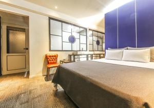 a hotel room with a large bed and a chair at Chuncheon Urbane Hotel in Chuncheon
