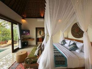 a bedroom with a bed with a canopy at Lira House by Yukaya Escape in Tegalalang