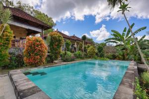 an image of a swimming pool in front of a house at Kampuak Cottages in Nusa Penida