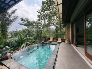 a swimming pool in the middle of a house at Lira House by Yukaya Escape in Tegalalang
