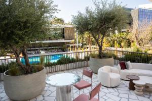 a patio with trees and chairs and a pool at Conrad Athens The Ilisian in Athens