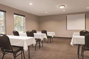 a conference room with tables and chairs and a whiteboard at Country Inn & Suites by Radisson, Dunn I-95 in Dunn