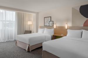 a hotel room with two beds and a desk at Spark By Hilton Seattle Airport in Seattle +31 photos