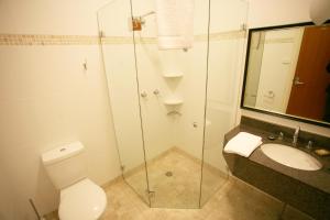 a bathroom with a shower and a toilet and a sink at Darcy's Hotel in Sydney