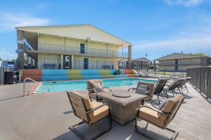 a patio with chairs and a table and a pool at Clarion Pointe Athens I-65 in Athens