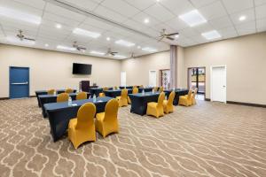 a conference room with tables and yellow chairs at Clarion Pointe Athens I-65 in Athens +80 photos