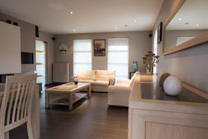 a living room with a couch and a table at VILLA WESTHOEK in Poelkapelle